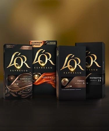 L'OR coffee capsules arranged on a dark table with various variants.